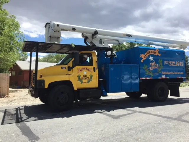 The 75-foot Altec GMC boom truck: yellow cab, blue body, Battle Born livery and phone number